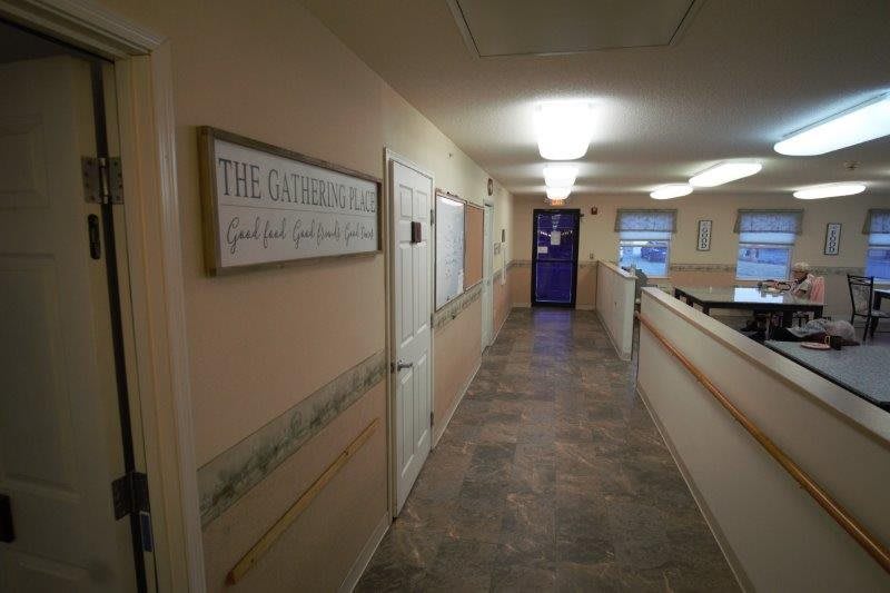 A well-lit indoor hallway with a sign on the wall.