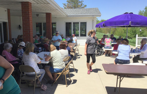 A lively outdoor community gathering on a sunny day, with people enjoying each other's company.