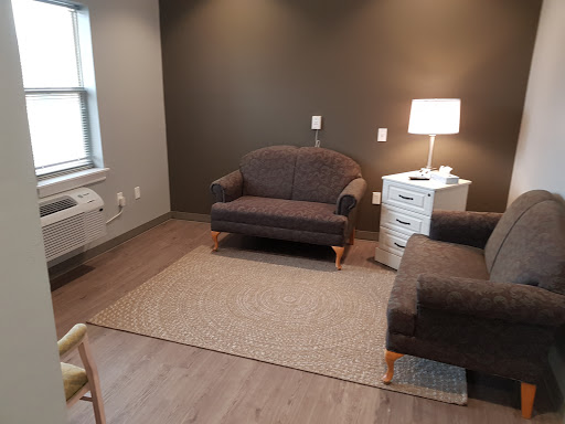 A cozy living room setup featuring a comfortable sofa, a side table with a lamp, and a stylish rug.