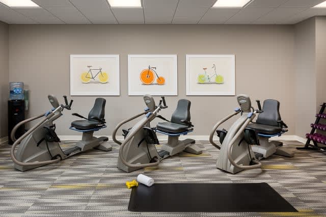 A modern gym with exercise bikes and colorful artwork on the walls.
