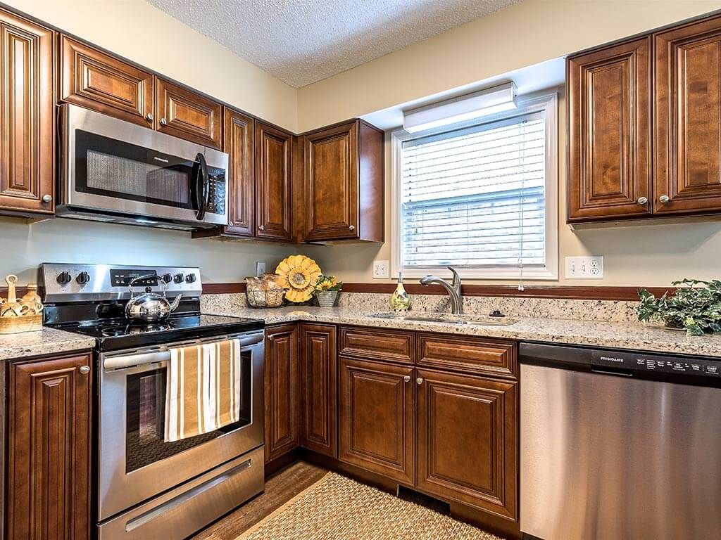 A modern kitchen with wooden cabinets and stainless steel appliances.