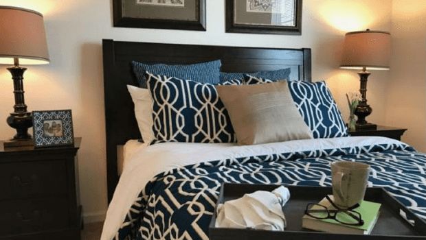 A cozy bedroom with stylish bedding and multiple pillows.