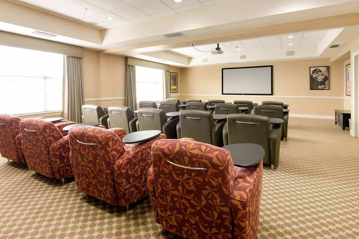 A cozy theater room with comfortable seating and a large projector screen.