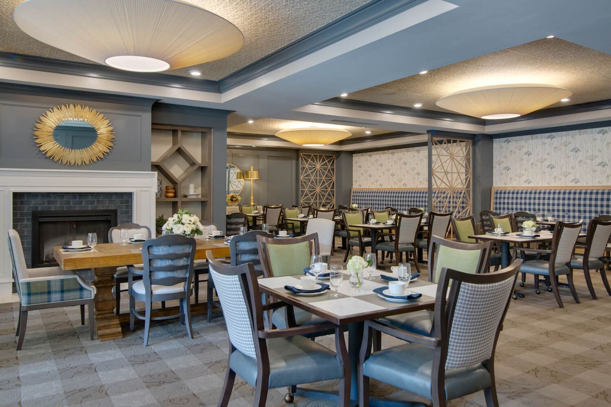 A modern restaurant dining area with neatly arranged tables and chairs, featuring elegant interior design and ambient lighting.