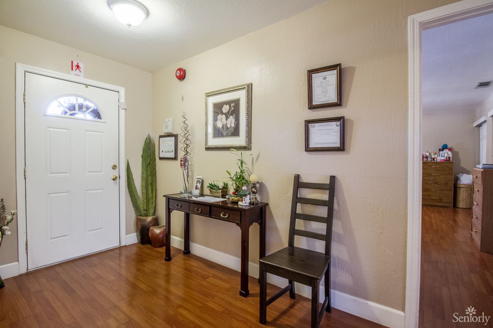 A warmly decorated entryway with a table, chair, and ornamental plants.
