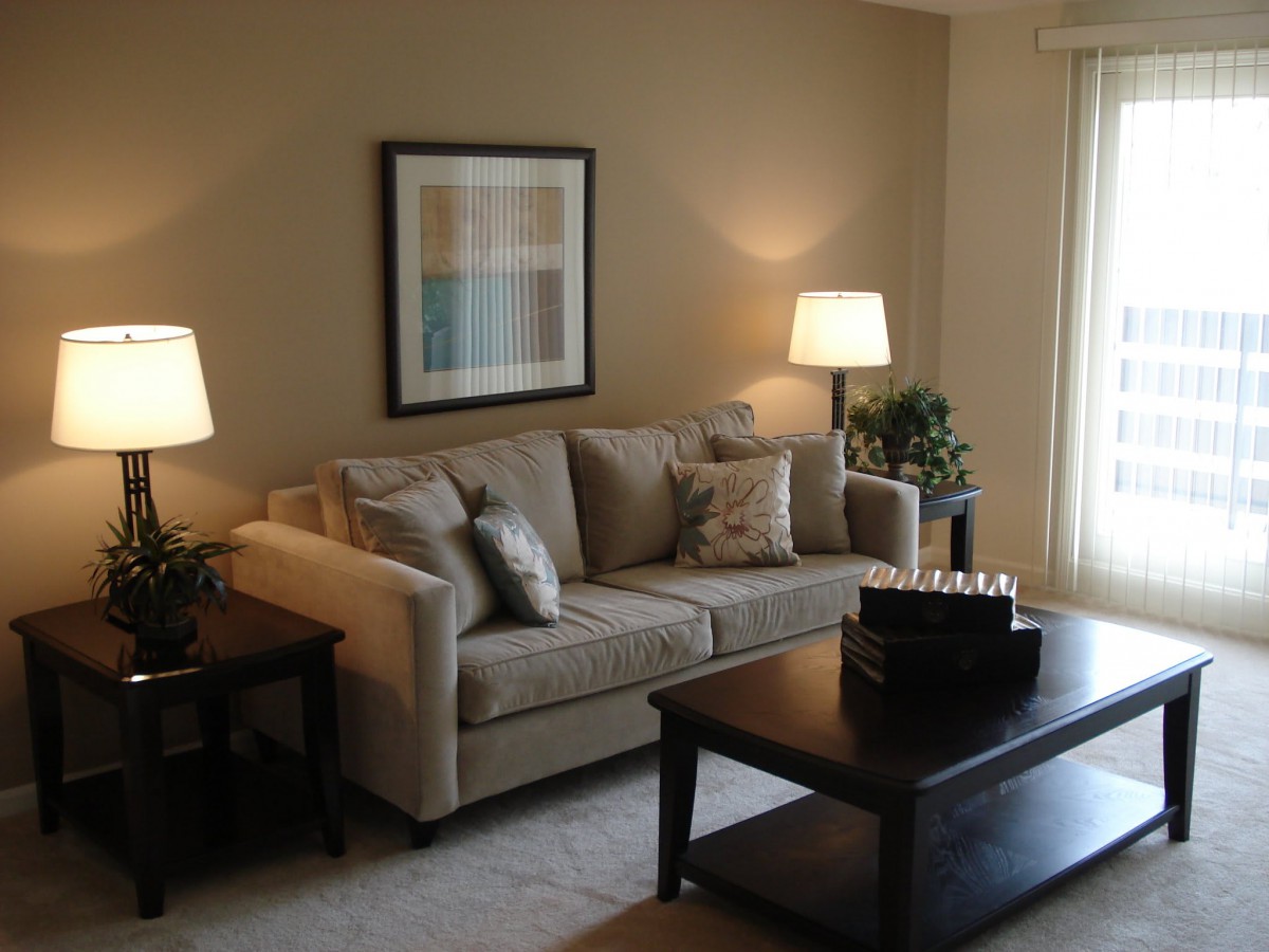 A cozy living room with a neutral-colored sofa, coffee table, and warm lighting.
