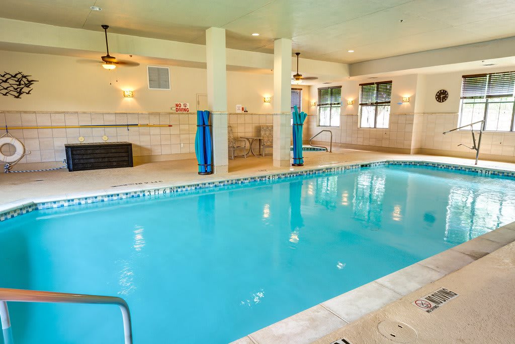 An inviting indoor swimming pool with clear blue water, surrounded by a bright and spacious environment.