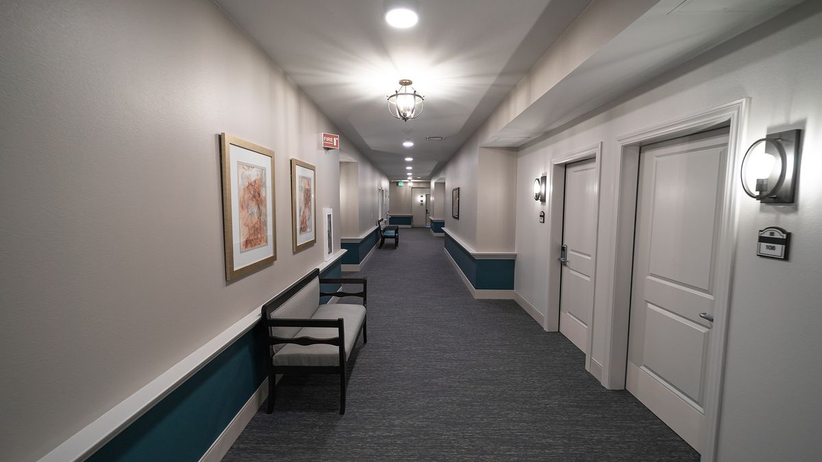 A well-lit hallway with benches and artwork on the walls.