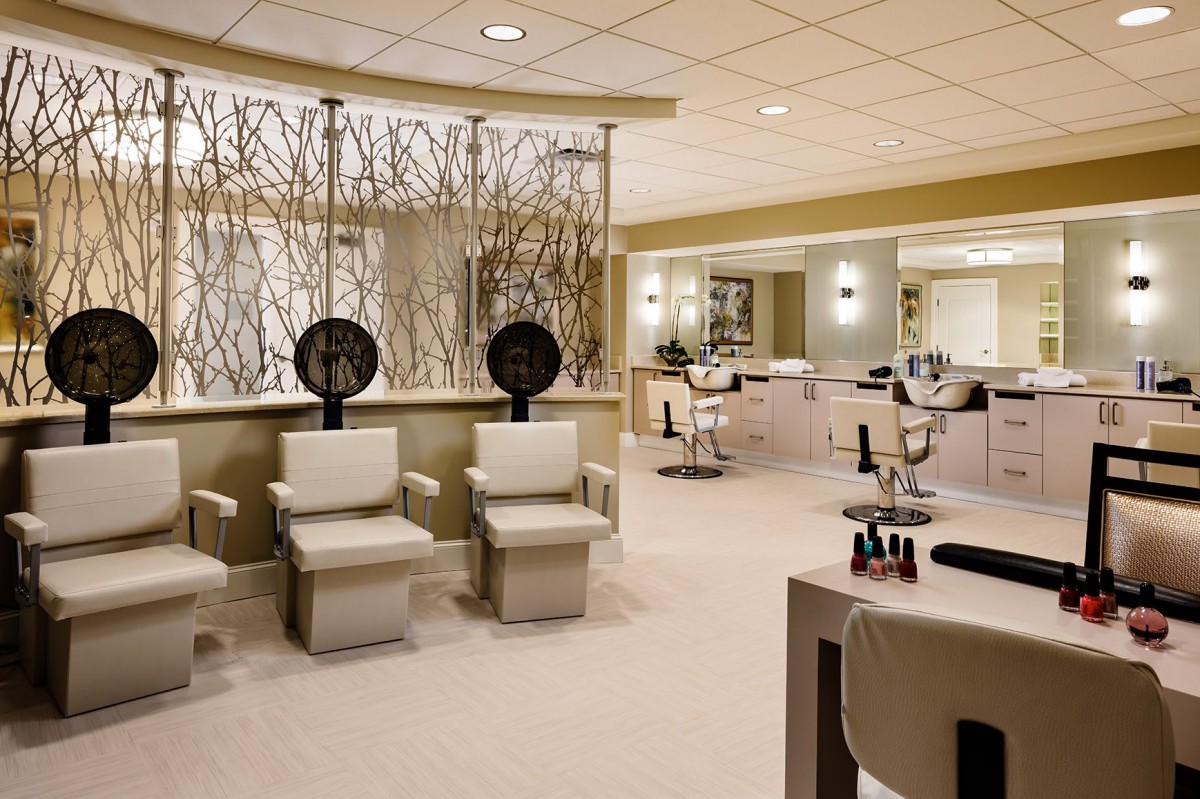 Modern salon interior with seating and mirrors.