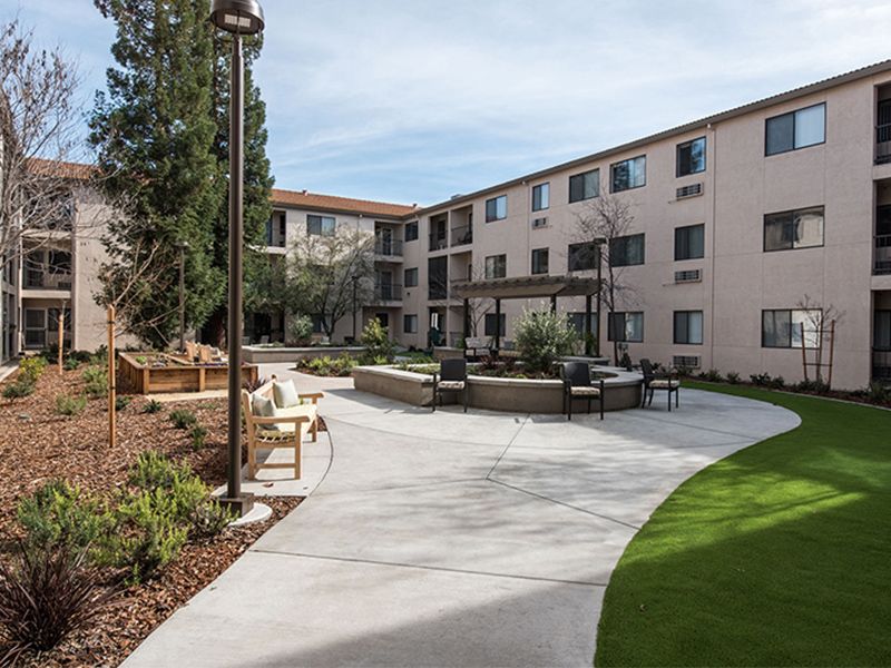 A well-maintained courtyard with seating areas outside an apartment building.