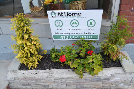 A garden sign promoting home services, surrounded by vibrant flowers.