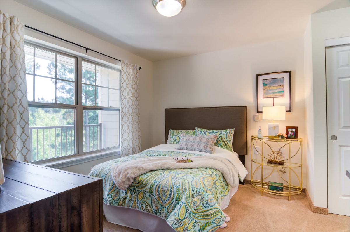 A cozy bedroom with a neatly made bed and modern decor.