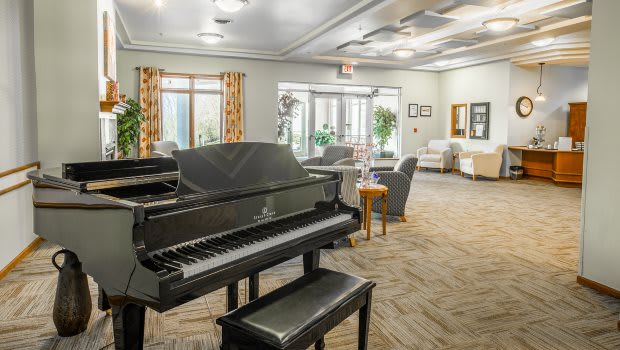 A cozy living room featuring a grand piano and comfortable seating.
