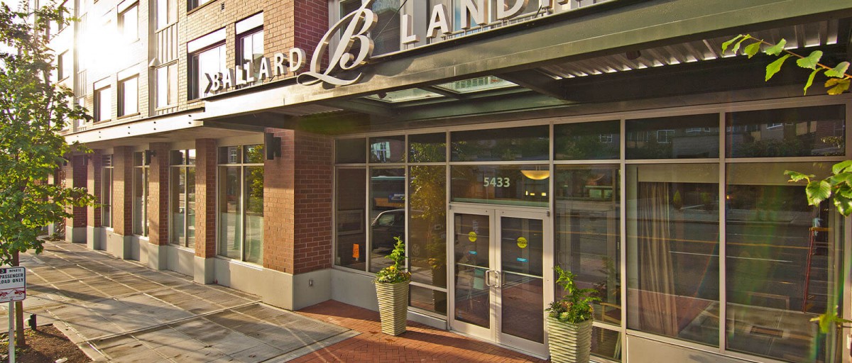 A modern storefront entrance with glass doors and large windows in an urban setting.