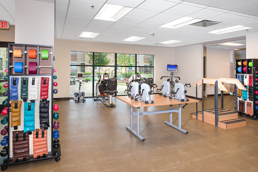 A well-equipped gym featuring various exercise machines and weights, providing a spacious area for workouts.