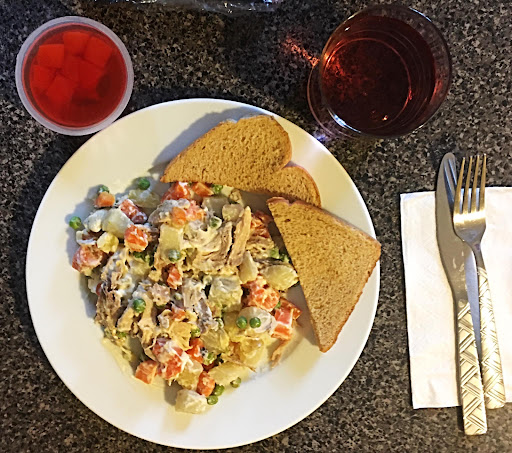 A hearty meal served with mixed vegetables, bread, and refreshing drinks.