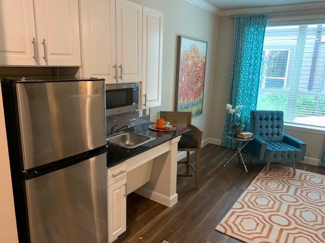 A modern apartment kitchen with stainless steel appliances and vibrant decor.