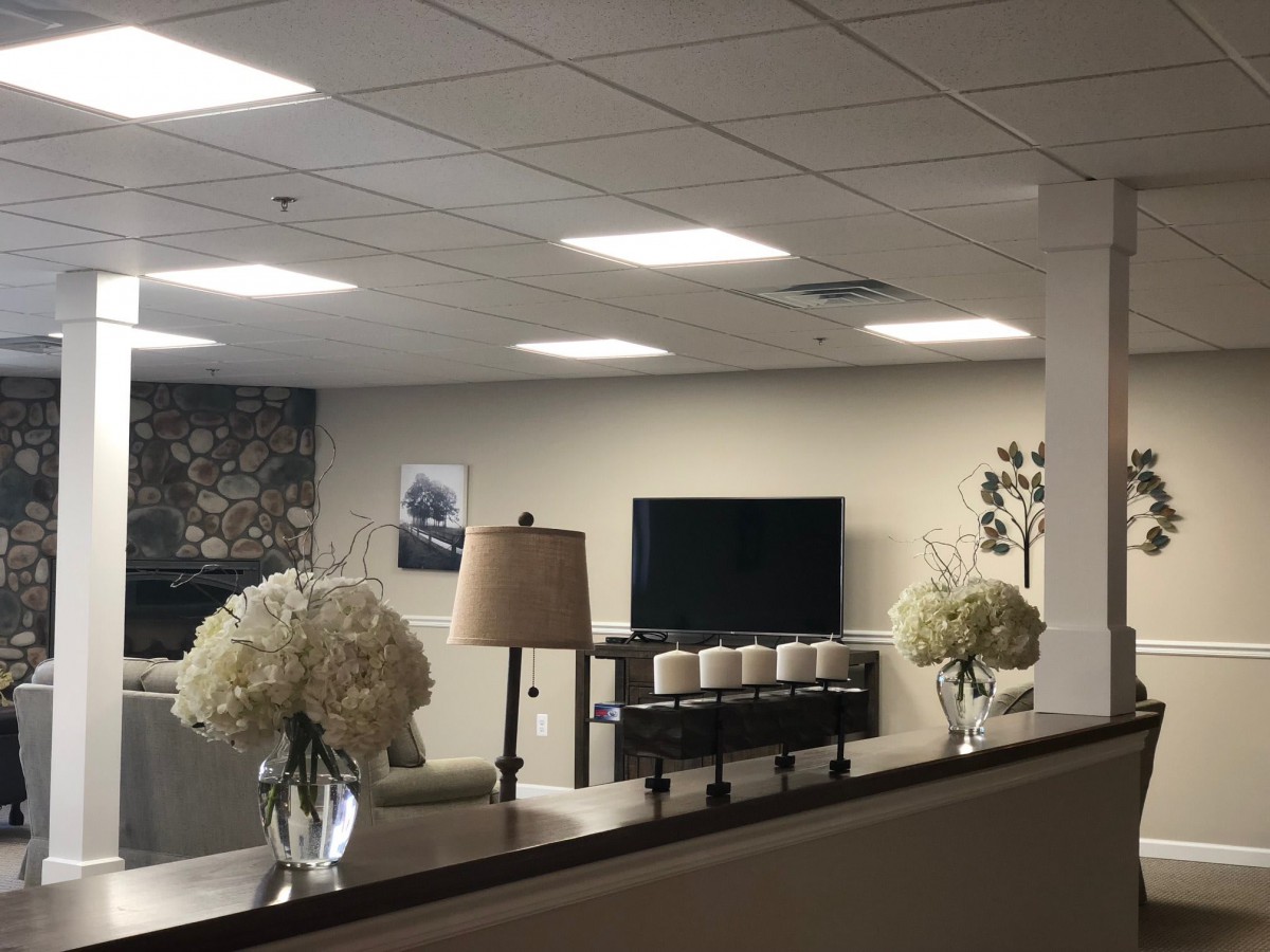 A modern living room with a television, sofa, and floral decorations.
