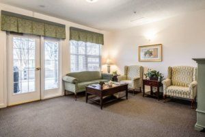 A cozy living room with a sofa, chairs, and a coffee table near large windows.