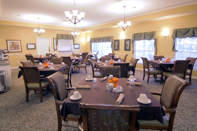 A well-arranged dining room with neatly set tables and elegant lighting.