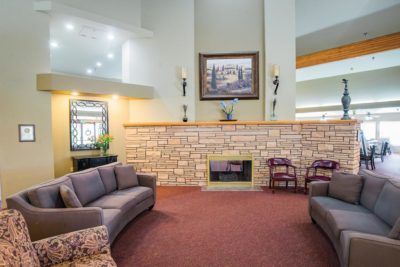 A spacious living room with modern decor, featuring comfortable sofas and a fireplace.