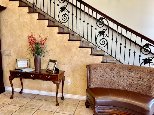 A beautifully designed interior featuring a staircase, elegant furniture, and decorative flowers.