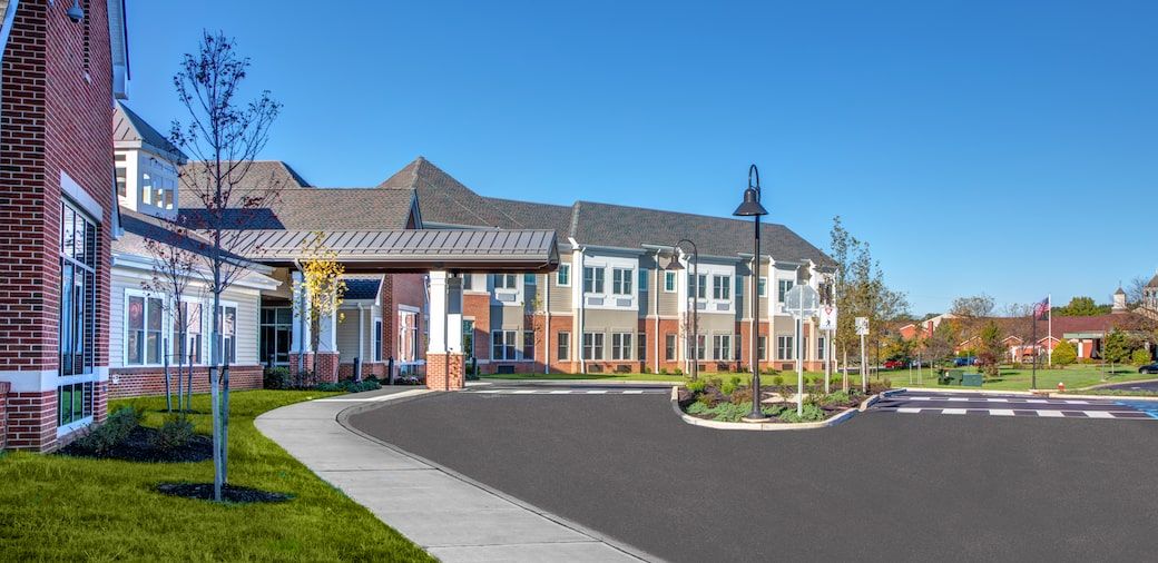 A modern residential building with landscaped surroundings and a clear blue sky.