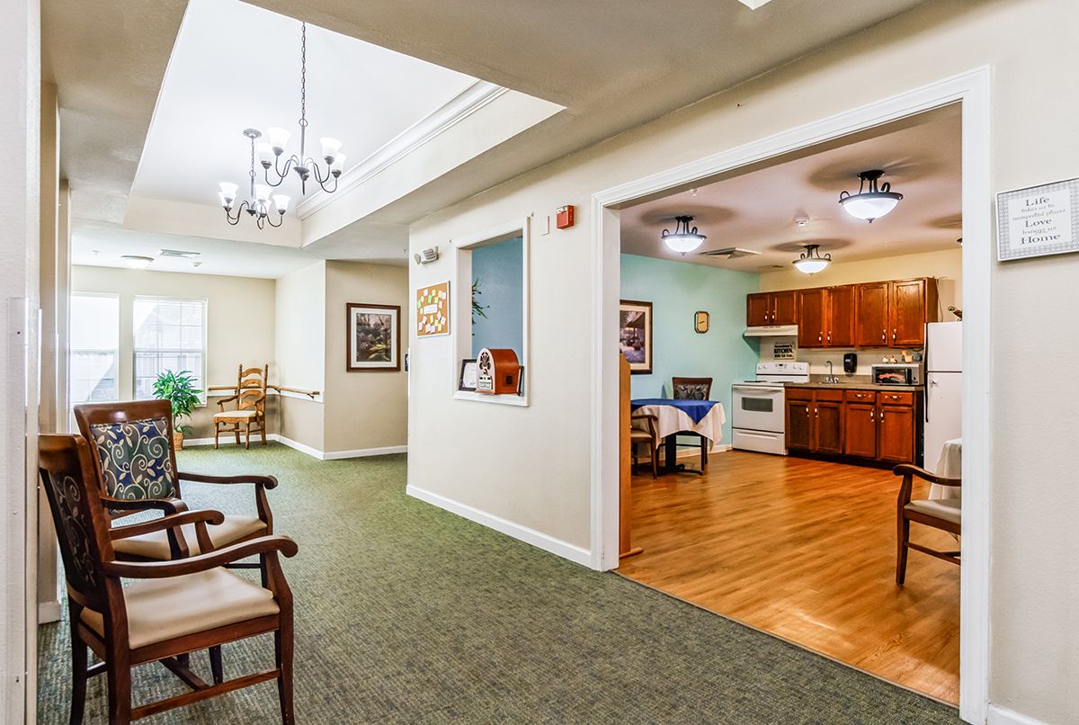A cozy interior featuring a kitchen and dining area with wooden flooring and adjacent living space with carpet.