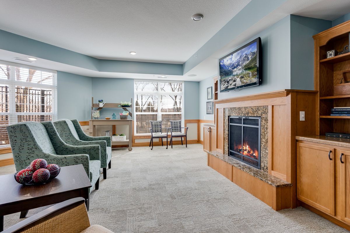 A cozy living room with a fireplace, television, and comfortable seating.
