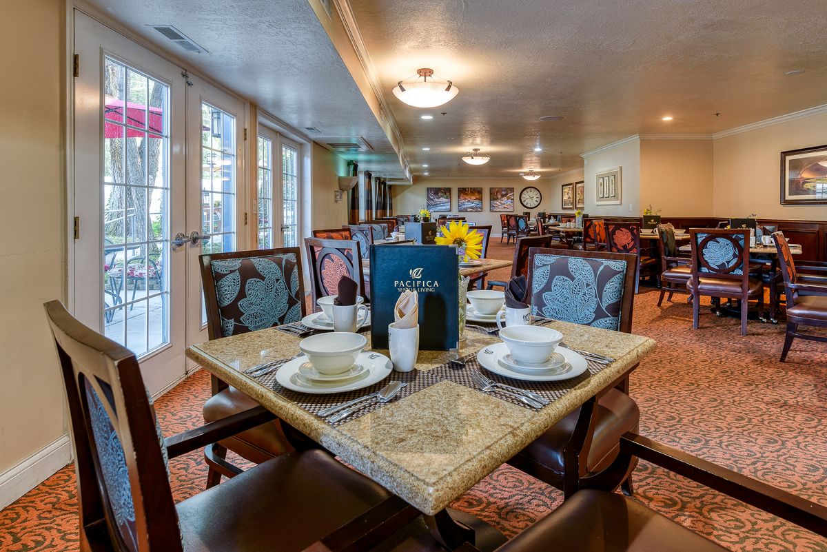 A well-arranged dining room with a table set for guests.
