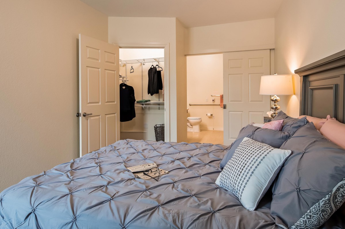 A cozy bedroom with a view of a walk-in closet and bathroom.