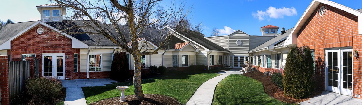 A suburban house with a well-maintained lawn and a sidewalk leading to the entrance.