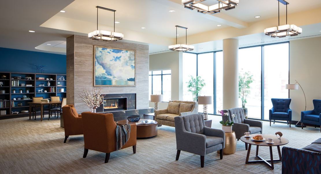 A modern lobby with comfortable seating, a fireplace, and contemporary artwork.