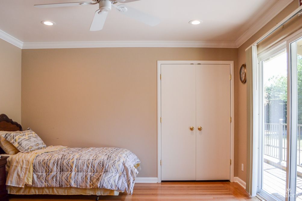 A minimalist bedroom with neutral tones, featuring a single bed and a closet.