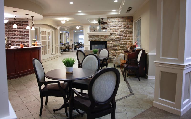 A cozy dining area with elegant furniture and a stone fireplace.