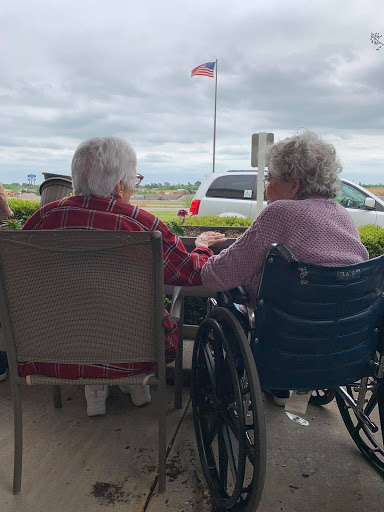 Two elderly friends enjoying each other's company outdoors, sharing a moment of connection.