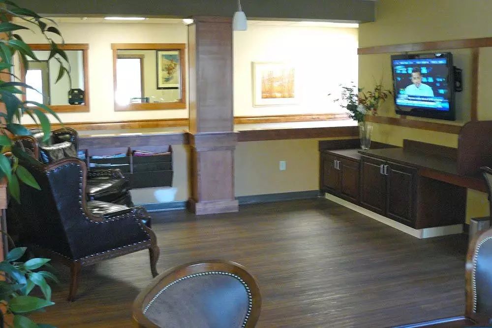 A cozy lobby area featuring comfortable seating and a wall-mounted television.