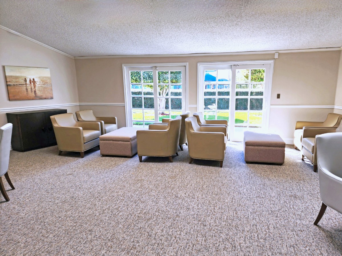 A spacious living room with modern furniture and large windows.