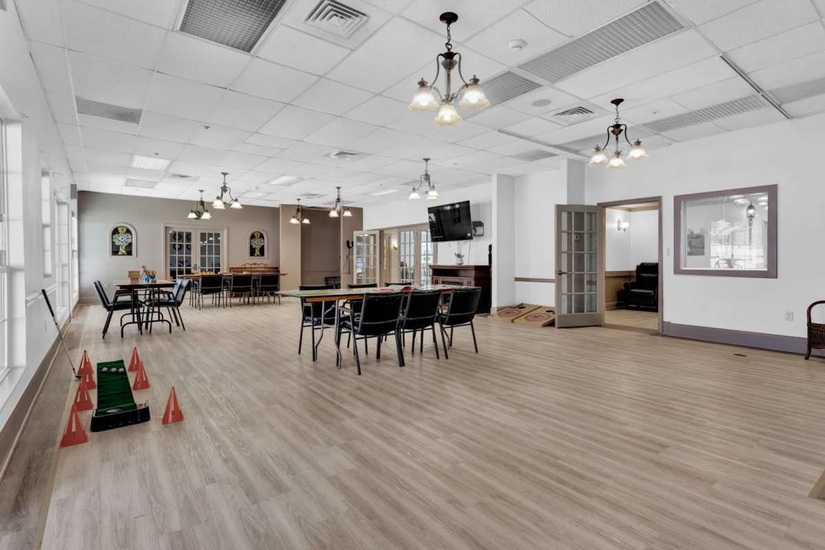 A modern dining area with tables, chairs, and ceiling lights.