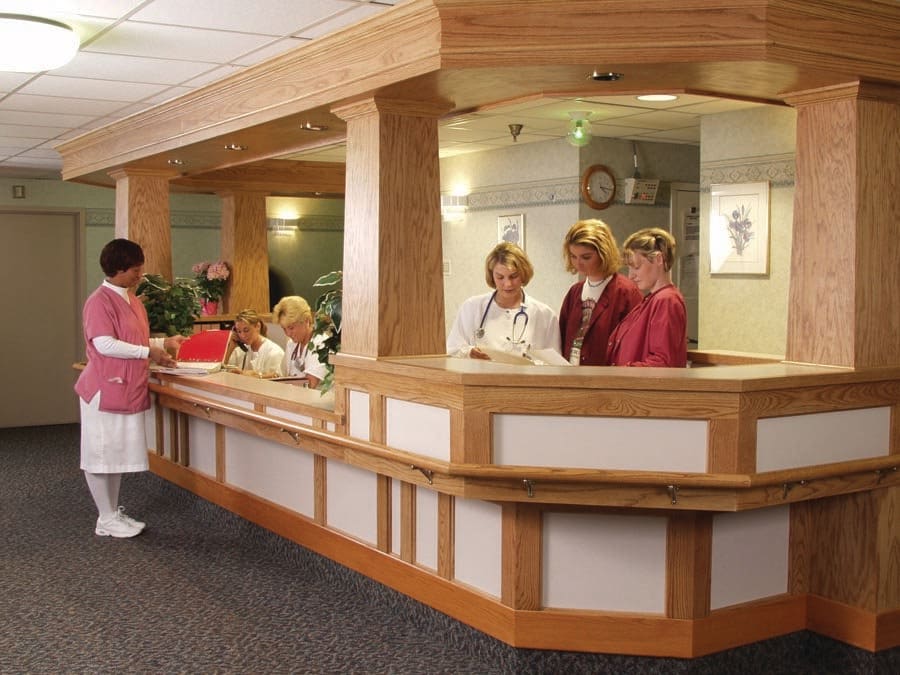 Medical staff working at a hospital reception desk.