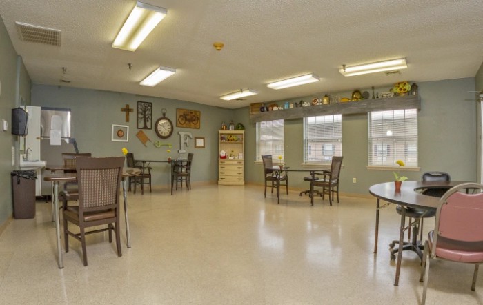 A spacious room with tables, chairs, and wall decor.