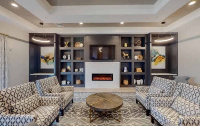 A modern living room with stylish furniture and a fireplace.