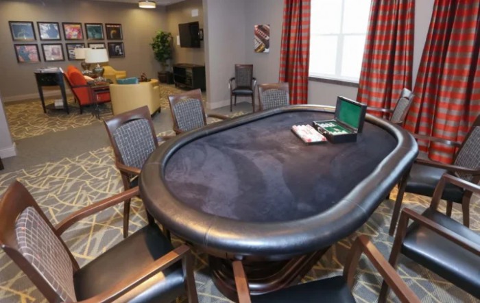 A poker table with chairs in a cozy game room setting.