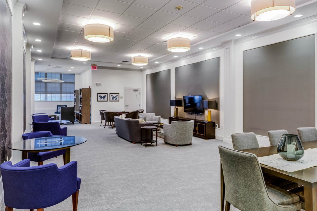 A modern lounge area with comfortable seating, stylish lighting, and a television set.