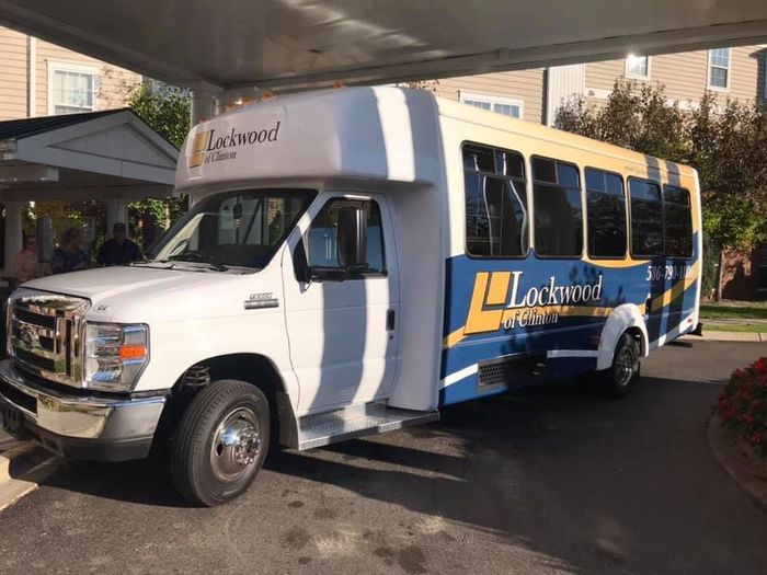 A shuttle bus parked in a lot, ready for passengers.