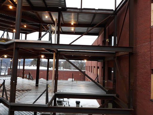 An interior view of a steel-framed building under construction, showcasing multiple levels and unfinished elements.