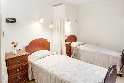 A cozy bedroom featuring two twin beds with simple decor and soft lighting.