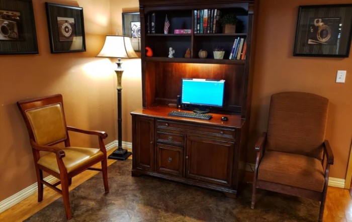 A cozy room with a computer desk and bookshelf setup.