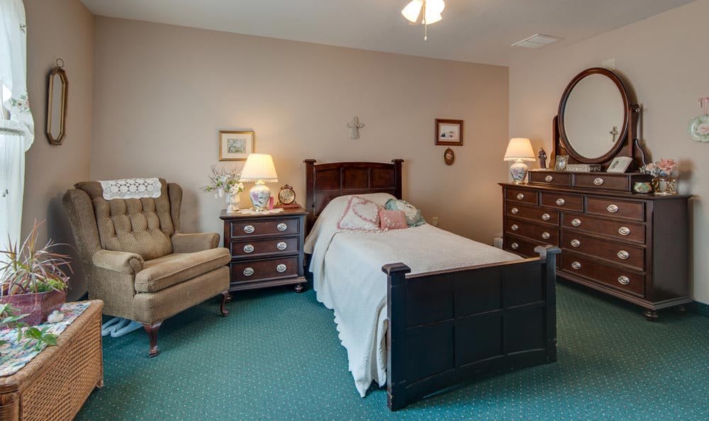 A cozy bedroom with a single bed, dresser, and bedside tables with lamps.