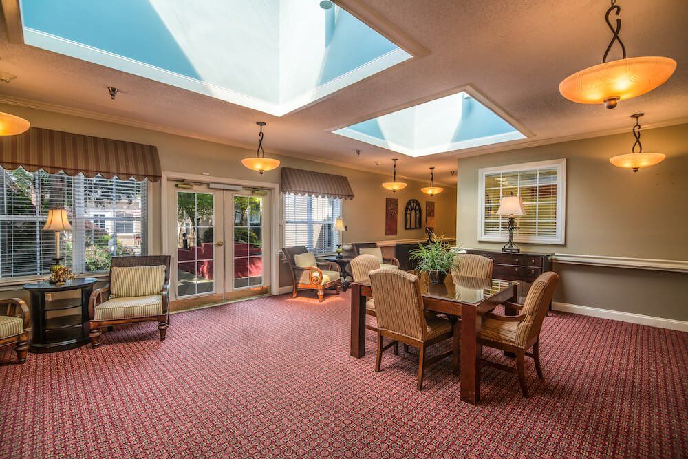 A cozy living room featuring large skylights, elegant furniture, and soft lighting.